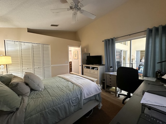 bedroom with a textured ceiling, a closet, vaulted ceiling, and ceiling fan