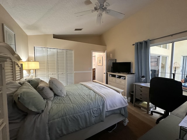 bedroom with a textured ceiling, ceiling fan, a closet, and lofted ceiling