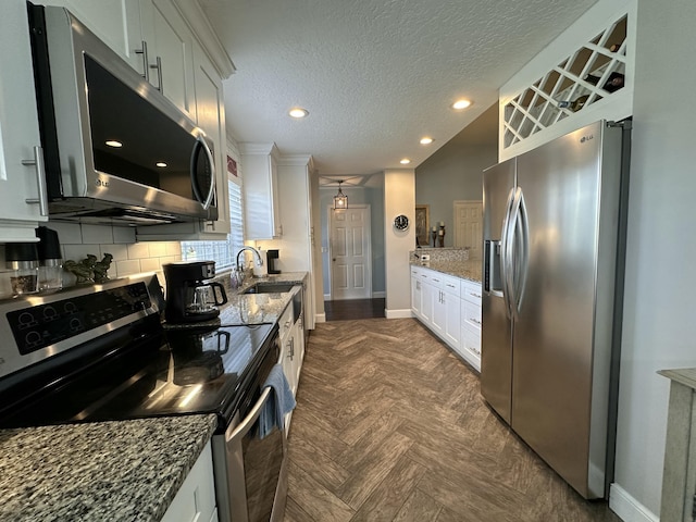 kitchen featuring decorative backsplash, white cabinets, and stainless steel appliances