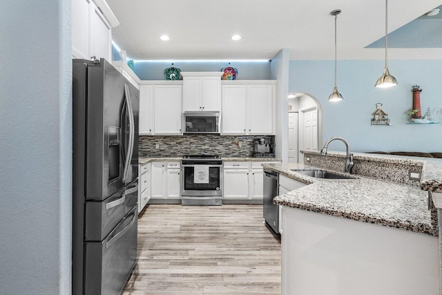 kitchen with white cabinetry, sink, hanging light fixtures, light stone counters, and stainless steel appliances