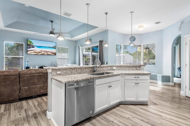 kitchen featuring pendant lighting, white cabinetry, sink, stainless steel dishwasher, and a raised ceiling