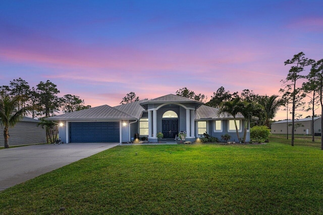 ranch-style home featuring a garage and a lawn