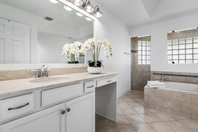 bathroom featuring vanity, tiled tub, and tile patterned floors