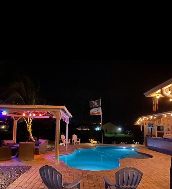 pool at twilight featuring a patio area and outdoor lounge area