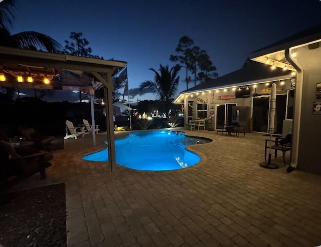 pool at twilight featuring a patio