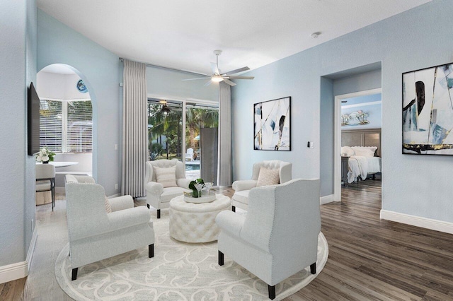 living room with ceiling fan and dark hardwood / wood-style flooring