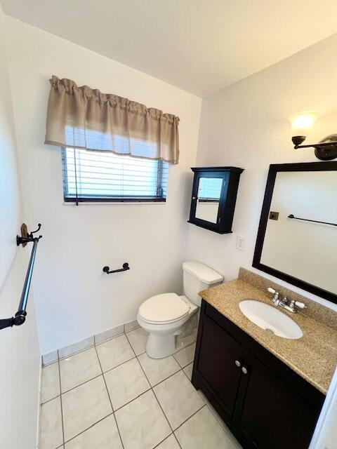 bathroom with vanity, toilet, and tile patterned flooring