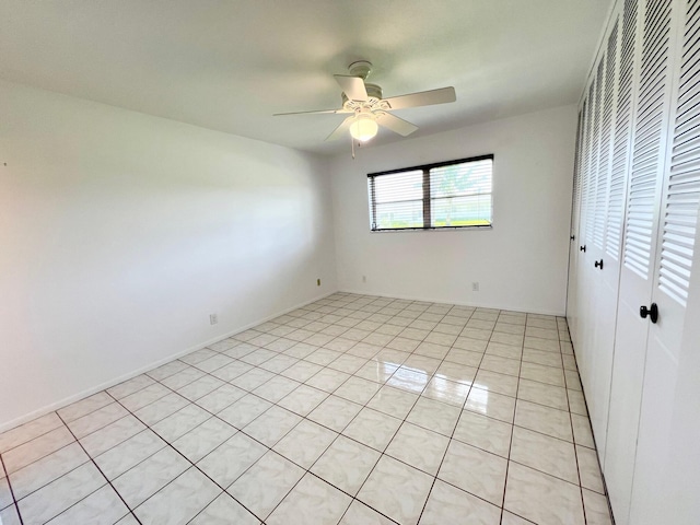 unfurnished bedroom with ceiling fan, a closet, and light tile patterned floors