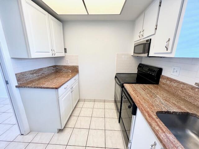 kitchen with tasteful backsplash, sink, black appliances, white cabinets, and light tile patterned flooring