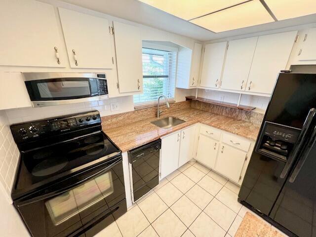 kitchen featuring white cabinets, sink, and black appliances