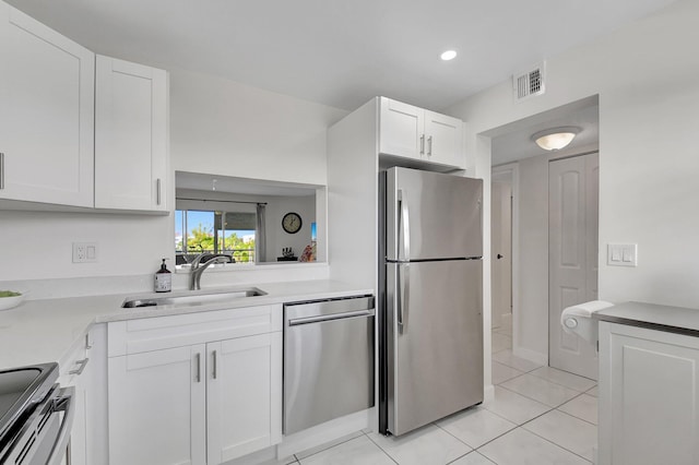 kitchen featuring white cabinets, light tile patterned flooring, sink, and appliances with stainless steel finishes