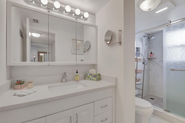 bathroom with vanity, toilet, and a shower with shower door