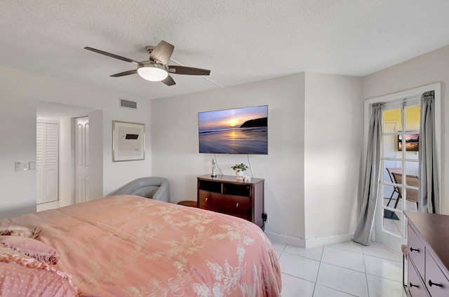 tiled bedroom featuring ceiling fan and a textured ceiling