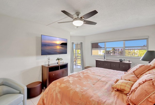 tiled bedroom featuring access to exterior, ceiling fan, and a textured ceiling