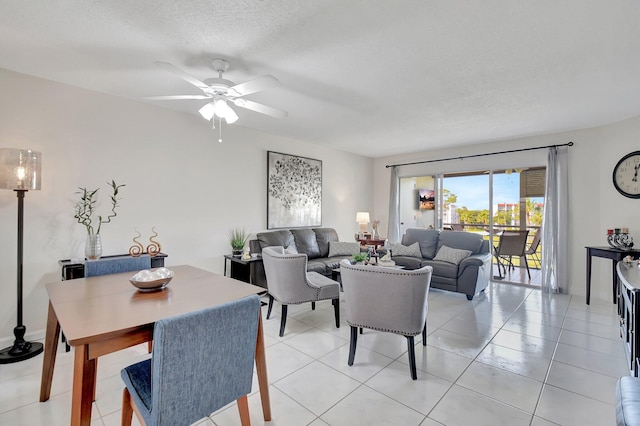 dining space featuring light tile patterned floors, a textured ceiling, and ceiling fan