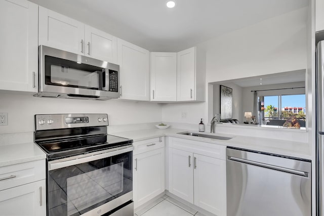 kitchen featuring light tile patterned flooring, sink, white cabinets, and stainless steel appliances