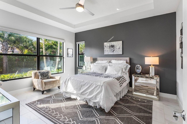 bedroom featuring ceiling fan and a raised ceiling