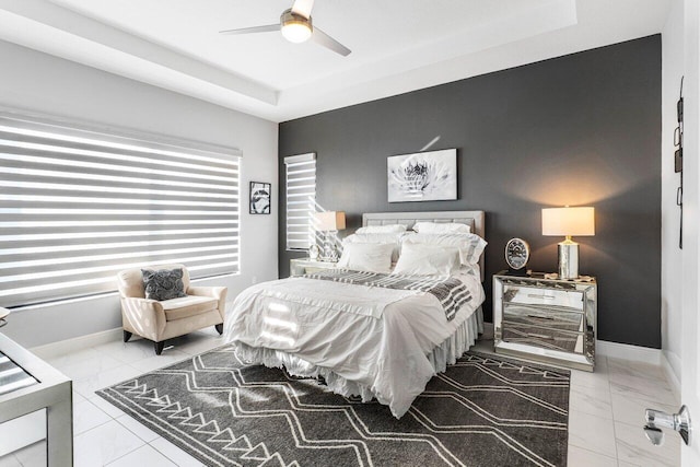 bedroom featuring a raised ceiling and ceiling fan