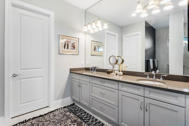 bathroom with a chandelier, vanity, and tile patterned flooring