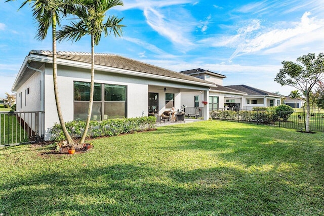 back of house with a yard, a patio, and ceiling fan