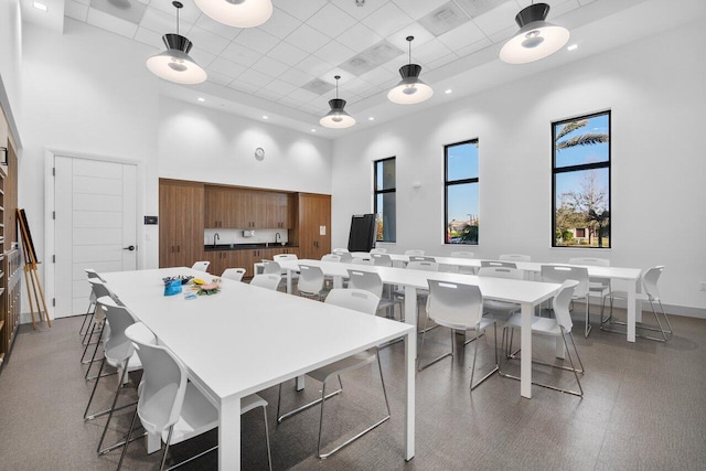 dining area featuring a towering ceiling and a paneled ceiling