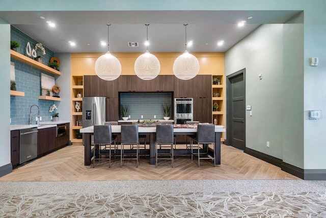 kitchen with decorative backsplash, a kitchen breakfast bar, stainless steel appliances, a center island, and light parquet flooring