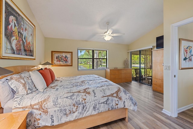 bedroom with ceiling fan, wood finished floors, baseboards, vaulted ceiling, and access to exterior