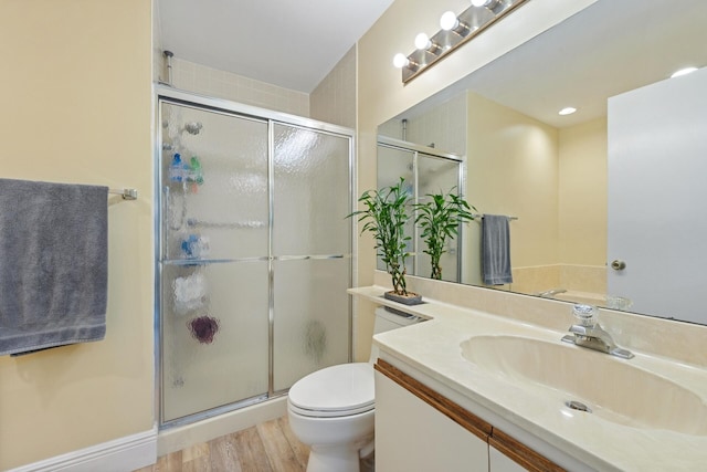 bathroom featuring hardwood / wood-style flooring, vanity, toilet, and a shower with door