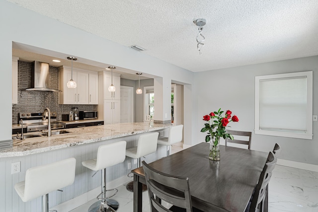 dining room with sink and a textured ceiling