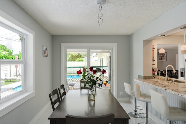 dining area featuring a textured ceiling and sink