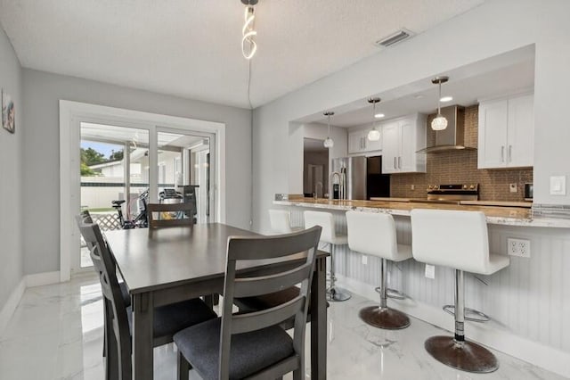 dining space featuring a textured ceiling and sink