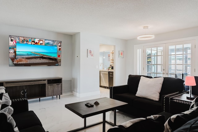 living room featuring french doors and a textured ceiling