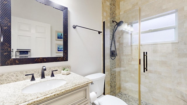 bathroom featuring vanity, a shower with shower door, and toilet