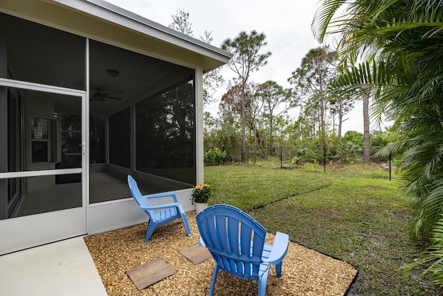 view of yard with a sunroom and ceiling fan