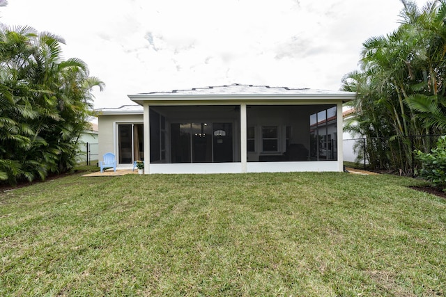 back of house with a sunroom and a yard