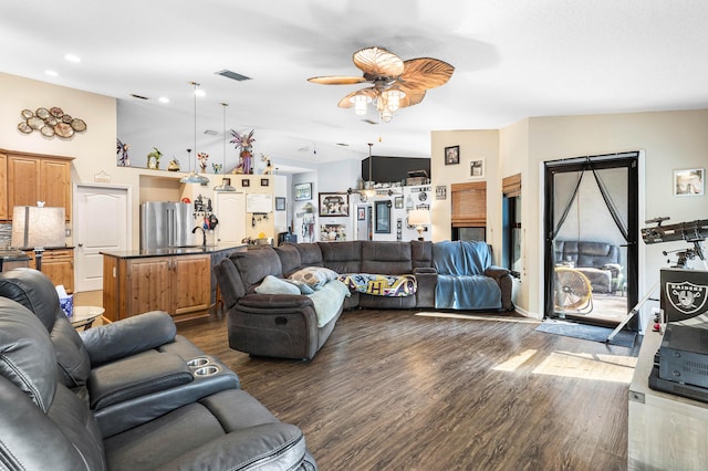 living room with ceiling fan, dark hardwood / wood-style flooring, vaulted ceiling, and sink