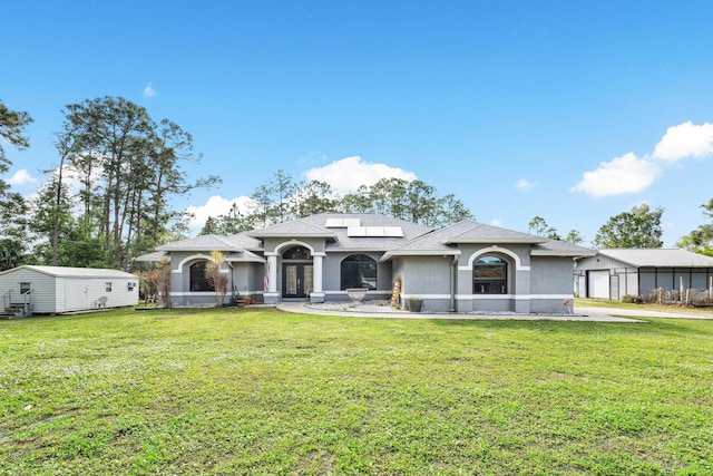 view of front of house with a front yard, solar panels, and french doors