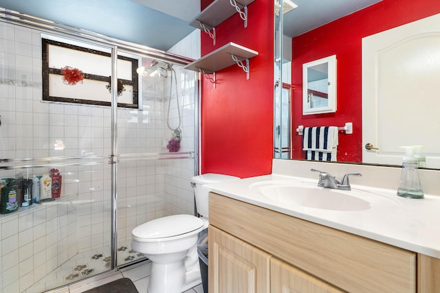 bathroom featuring tile patterned flooring, toilet, vanity, and walk in shower