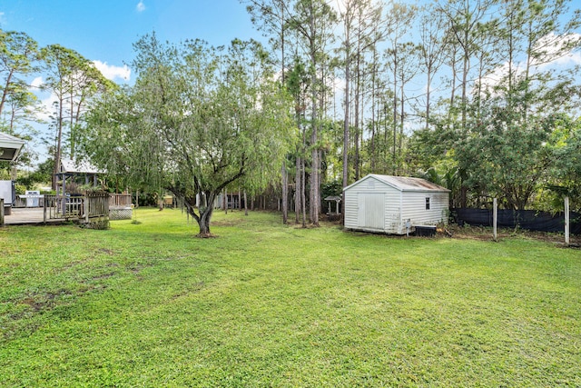 view of yard featuring a deck and a storage shed