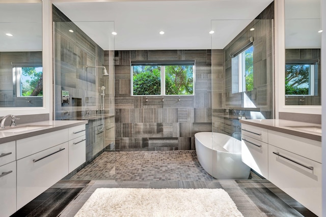 bathroom with tile patterned floors, vanity, tile walls, and shower with separate bathtub