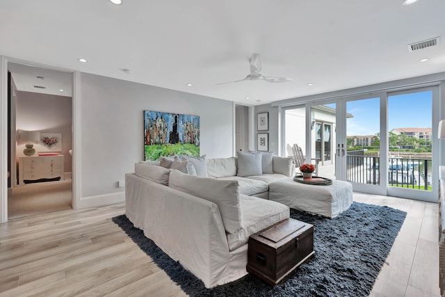 living room with light hardwood / wood-style floors, floor to ceiling windows, and ceiling fan