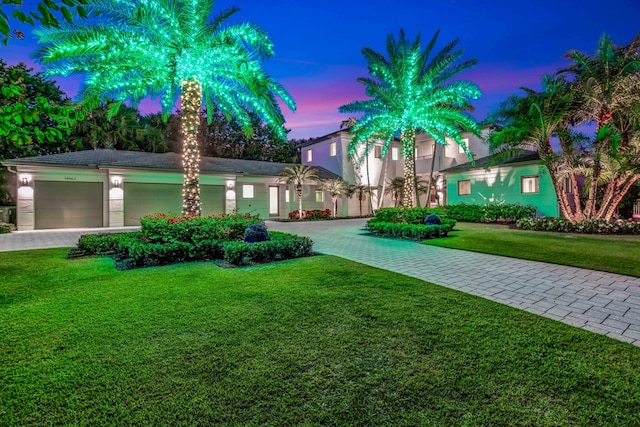 view of front of property with a garage and a lawn