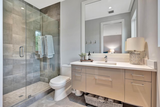 bathroom featuring tile patterned floors, vanity, toilet, and a shower with shower door