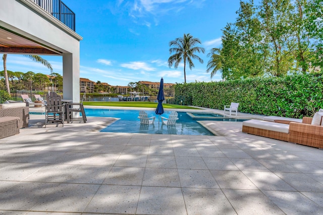 view of pool with a patio and a water view