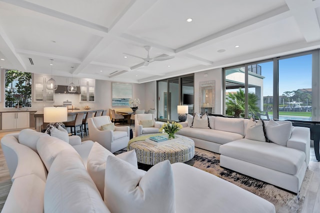 living room featuring beam ceiling, light wood-type flooring, ceiling fan, and coffered ceiling