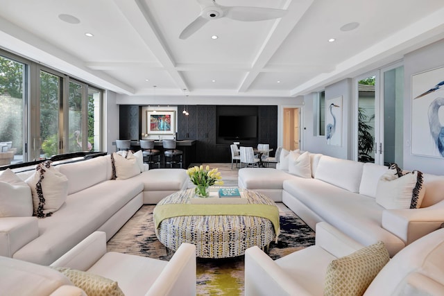 living room with beamed ceiling, ceiling fan, and coffered ceiling