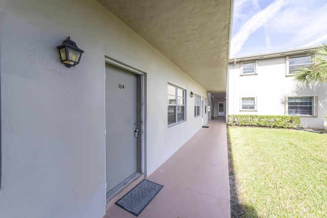 doorway to property with a lawn