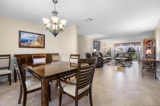 tiled dining room with an inviting chandelier