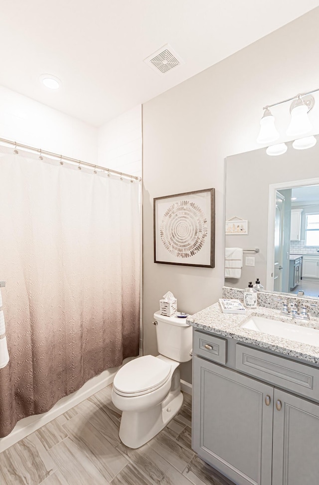 bathroom featuring vanity, hardwood / wood-style floors, and toilet