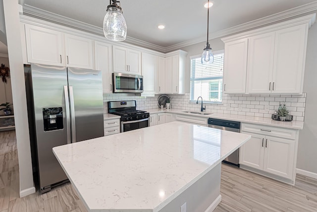 kitchen with appliances with stainless steel finishes, sink, white cabinets, and decorative light fixtures